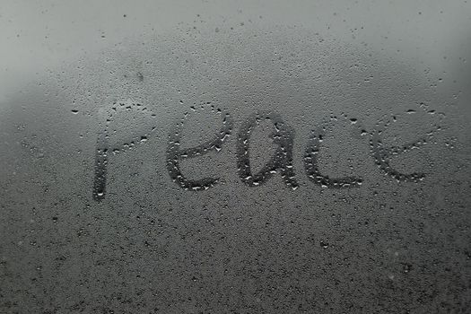 word peace on a foggy window.