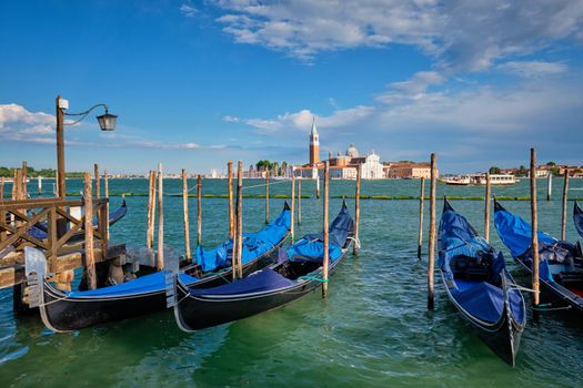 Gondolas and in lagoon of Venice by Saint Mark (San Marco) square with San Giorgio di Maggiore church in background in Venice, Italy