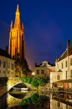 Church of Our Lady and canal illuminated in the night. Brugge Bruges, Belgium