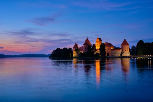 Night view of Trakai Island Castle in lake Galve illuminated in the evening, Lithuania