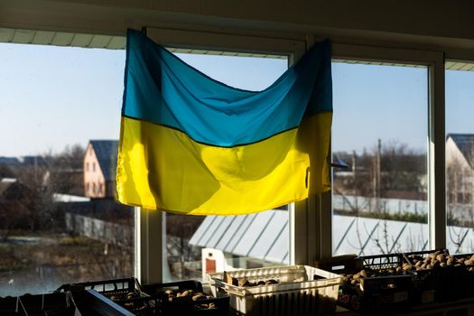 Support Ukraine. Ukrainian flag on the window. Place for text