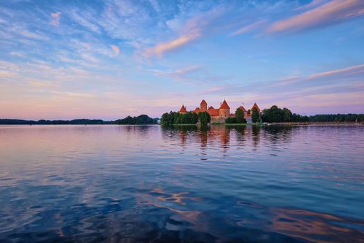 Trakai Island Castle in lake Galve, Lithuania on sunset with dramatic sky reflecting in water. Trakai Castle is one of major tourist attractions of Lituania