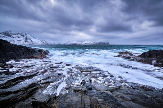 Waves of Norwegian sea crushing at rocky coast in fjord. Vikten, Lofoten islands, Norway