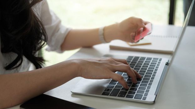 Woman using laptop computer for online shopping purchase with credit card.