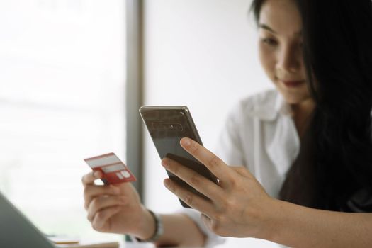 Shopping online with smartphone and credit card on hand.