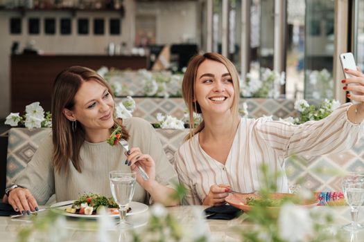 Two Women Making Selfie While Having Lunch Meeting, Female Friends Eating Salad in Restaurant