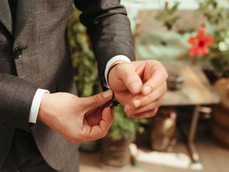 Businessman wearing the wristwatch. Grain effect. sunny