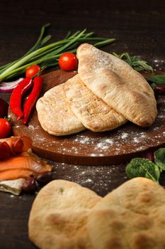 Doner kebab or pita on a wooden tray.