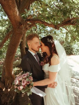 Happy wedding couple walking in a botanical park grain effect