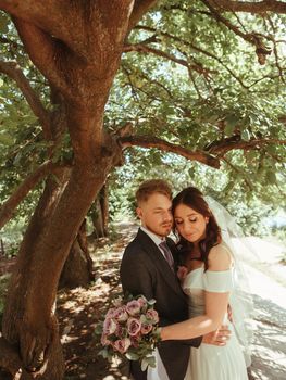 Happy wedding couple walking in a botanical park grain effect