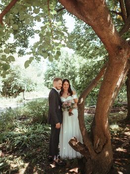 Happy wedding couple walking in a botanical park grain effect