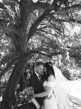 Happy wedding couple walking in a botanical park grain effect