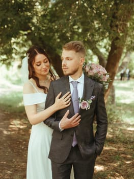 Happy wedding couple walking in a botanical park grain effect