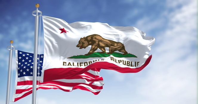 The California state flag flying along with the national flag of the United States of America. In the background there is a clear sky. The flag depicts a walking bear and a five-pointed red star