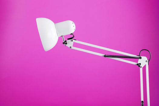 White table office lamp on pink background with space for text and idea concept