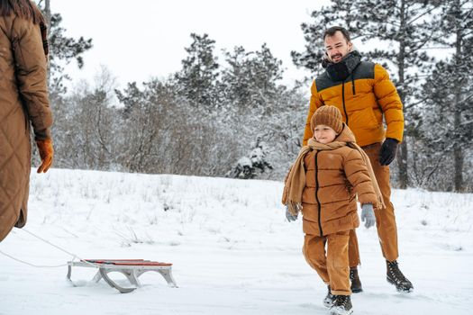 Father and son playing in the park on winter snowy day