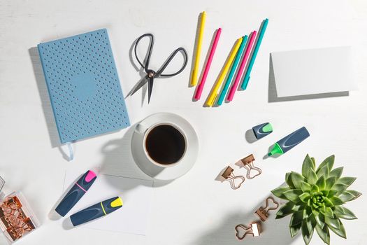 Layout for the office. Back to school. Blue notebook, colorful pens, felt-tip pens, paper clips, potted echeveria, a cup of tea. Place for text