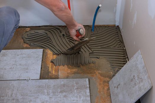 Adhesive ceramic tiles with tilers mortar tiles using a trowel on home improvement, renovation