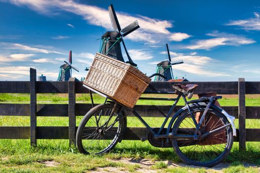 Bicycle with windmill and blue sky background. Scenic countryside landscape close to Amsterdam in Netherlands.