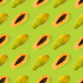 Fresh ripe papaya seamless pattern on green background. Tropical abstract background. Top view. Creative design, minimal flat lay concept. Trend tropical fruit food background pattern