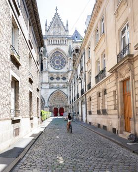 woman on bike in city centre of reims in the north of france near famous cathedral