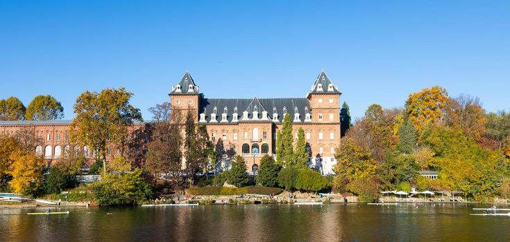 Turin, Italy - Circa November 2021: outdoors panorama with scenic Turin castle and people canoeing in Po' river