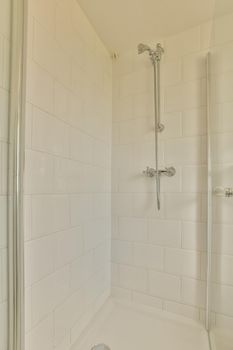 The interior of a bathroom with a shower cabin with a glass wall in a cozy house