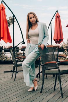 Sexy stylish woman with a blond hair wear blue cotton suit posing on the street. summer collection style fashion.