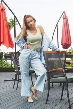 Sexy stylish woman with a blond hair wear blue cotton suit posing on the street. summer collection style fashion.