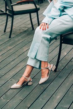 female legs in blue cotton pants and beige shoes. Summer fashion