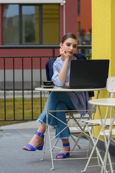 Charming happy woman student using laptop computer to prepare for the course work. Concept of working outdoors