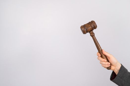 Woman holding judge's gavel on white background