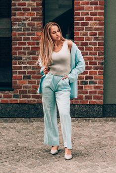 Sexy stylish woman with a blond hair wear blue cotton suit posing on the street. summer collection style fashion.