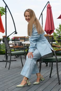 Sexy stylish woman with a blond hair wear blue cotton suit posing on the street. summer collection style fashion.