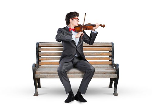 Young businessman plays the violin sitting on a wooden bench. Inspiration in business