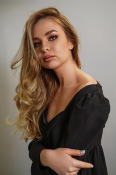 Beautiful young blonde woman face closeup portrait in studio on a light background.