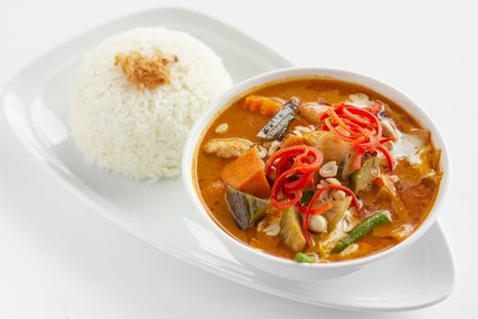 traditional spicy thai chicken red curry with steamed rice on white background