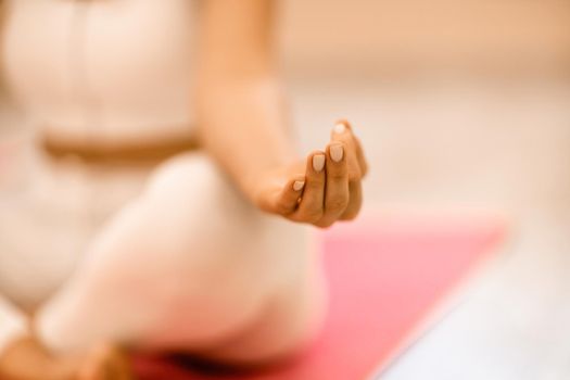 Girl does yoga. Young woman practices asanas on a beige one-ton background