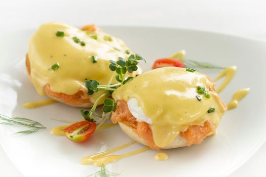 eggs benedict royale breakfast with smoked salmon and hollandaise sauce on white background in modern restaurant