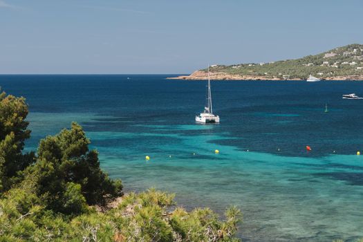 Sailing yacht stay in dream bay with turquoise transparent water. Ibiza island, Spain.