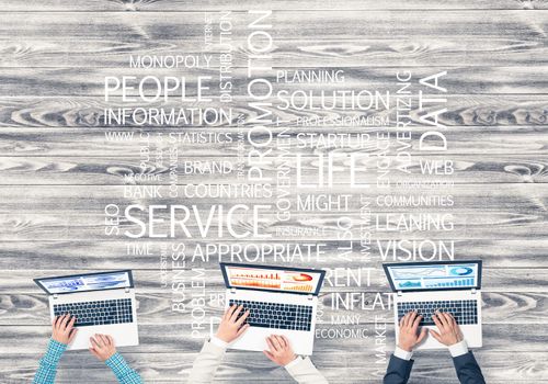 Group of three people with devices in hands working together as symbol of networking and communication