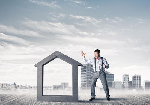 Determined businessman going to break with fist house concrete figure