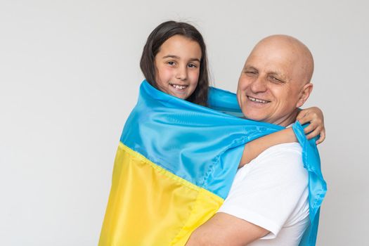 elderly man and girl with the flag of Ukraine.