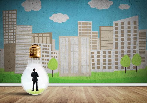 Businessman inside light bulb against city drawn concept