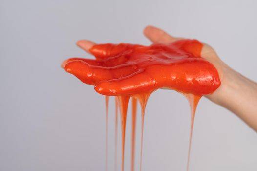 Red slime flowing down from a woman's hand on a white background
