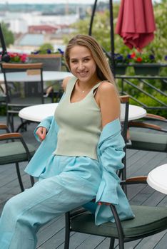 Sexy stylish woman with a blond hair wear blue cotton suit posing on the street. summer collection style fashion.