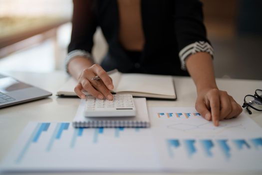 Businesswoman accountant or financial expert analyze business report graph and finance chart at corporate office. Concept of finance economy, banking business and stock market research