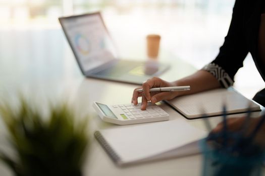 Close up a accountant working about financial with calculator at office to calculate expenses, Accounting concept.