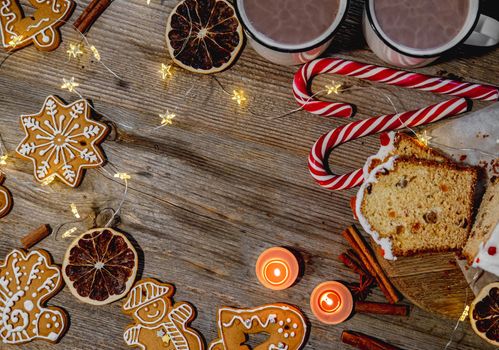 Traditional gingerbread figures and other christmas decorations on wooden background, view from above