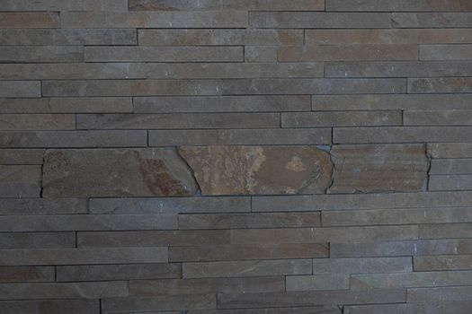 Elegant stone cladding wall made of gray granite with different shades.
